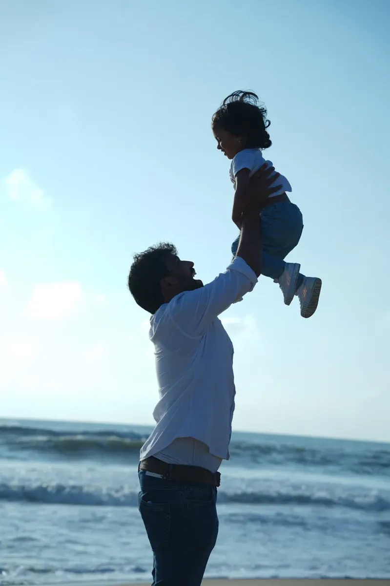 Dad tossing his little one by the sea
