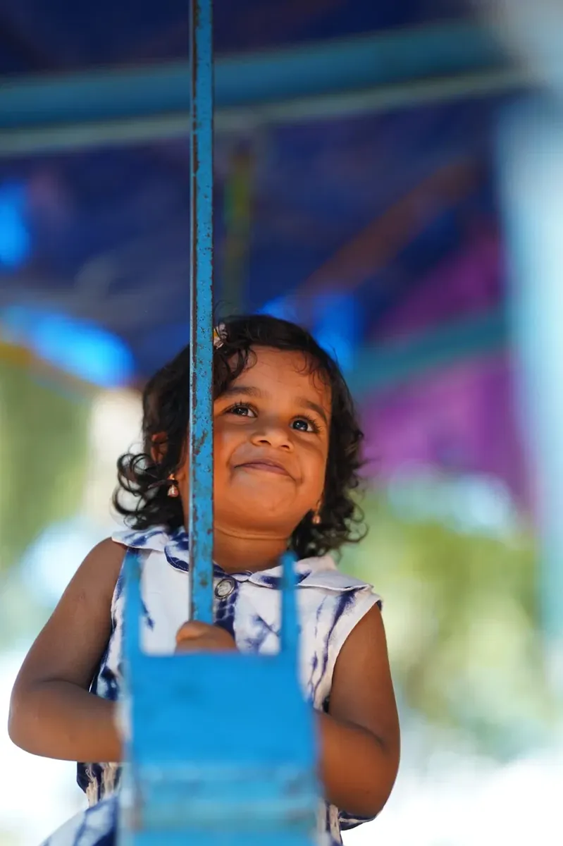 Little girl grinning on a swing
