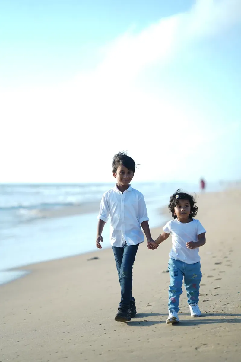 Brother and sister walking on the beach
