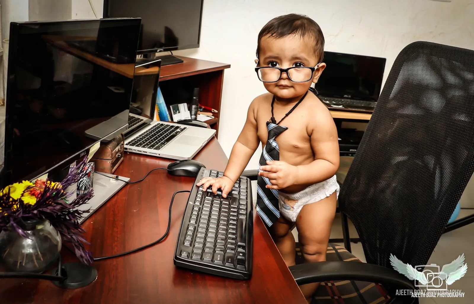Baby in glasses and a tie at the office desk, fun baby photoshoot — kids and baby photography by Ajeeth Boaz Photography, Chennai
