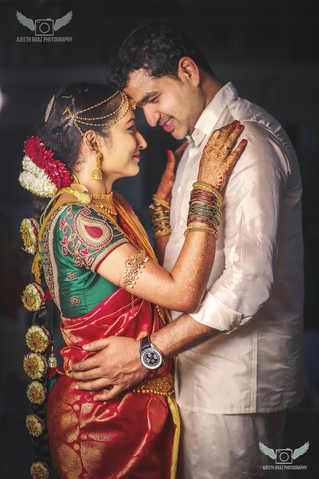 Couple holding each other close in a dark, dramatic wedding portrait — candid wedding photography by Ajeeth Boaz Photography, Chennai