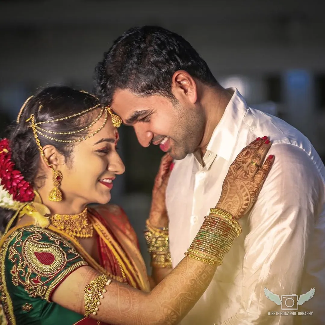 Bride and groom forehead to forehead in traditional silk and jewellery — candid wedding photography by Ajeeth Boaz Photography, Chennai